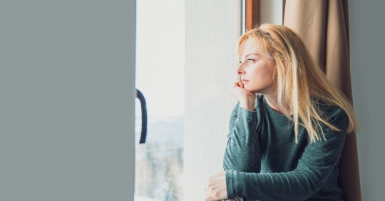 sad woman looking out the window